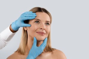 Gloved hands touching a woman’s face