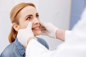 Patient looking at doctor during plastic surgery consultation